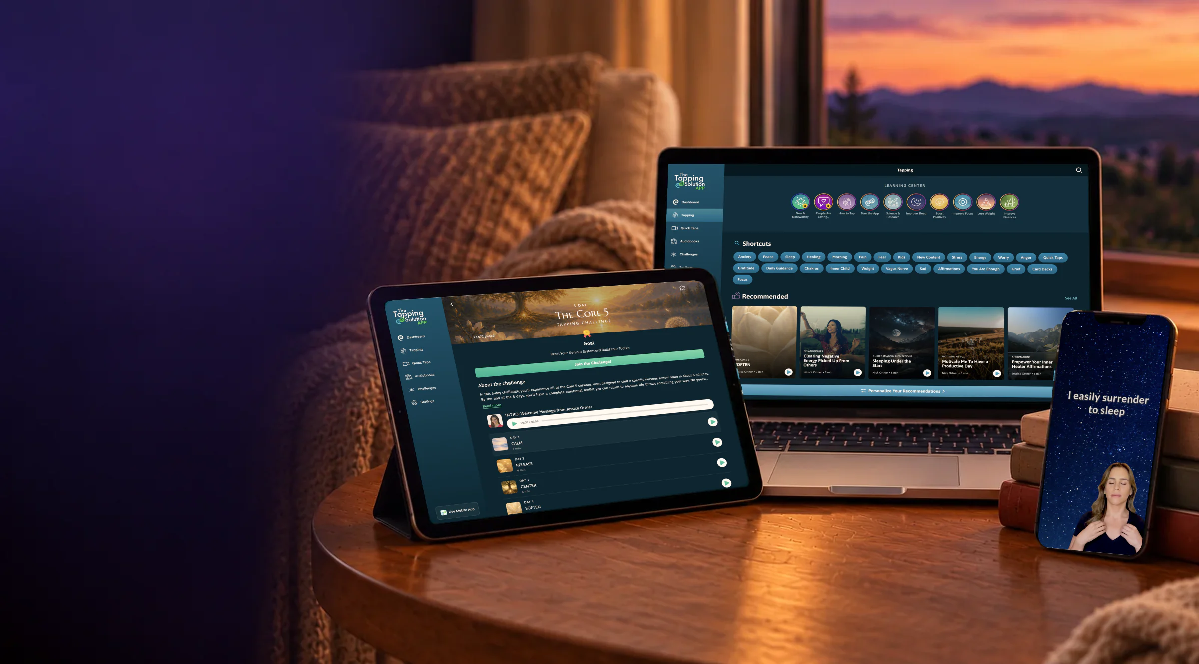 The Tapping Solution app on a laptop, tablet and phone by a window at sunset