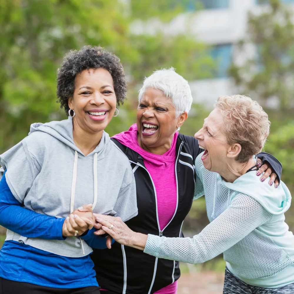 Three women laughing together outdoors